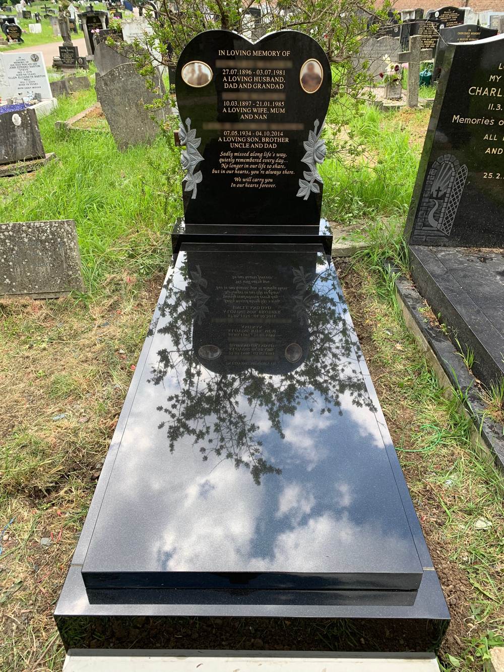 Black Granite heart shaped headstone with carved roses upon return end kerb set with cover slab.