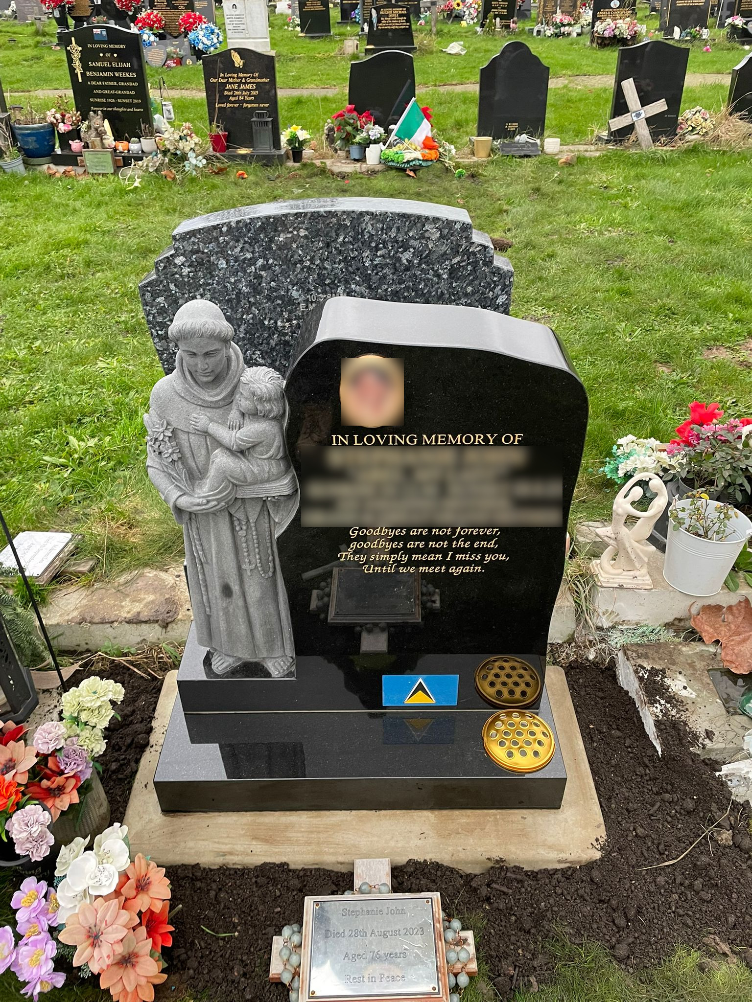 Black granite lawn memorial with hand carved St Anthony figure.
