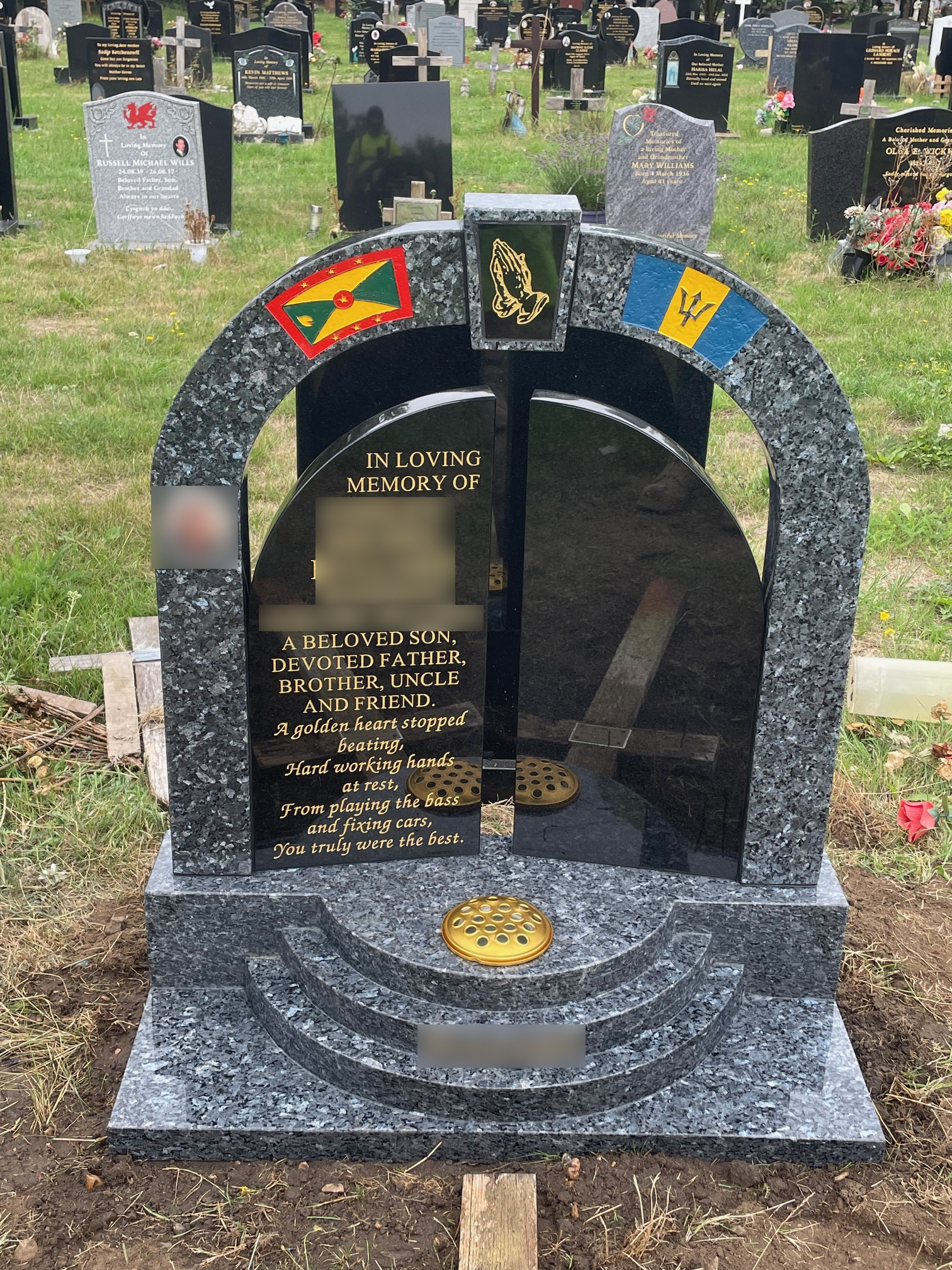 Blue pearl and black granite gates of heaven lawn memorial with stepped base.