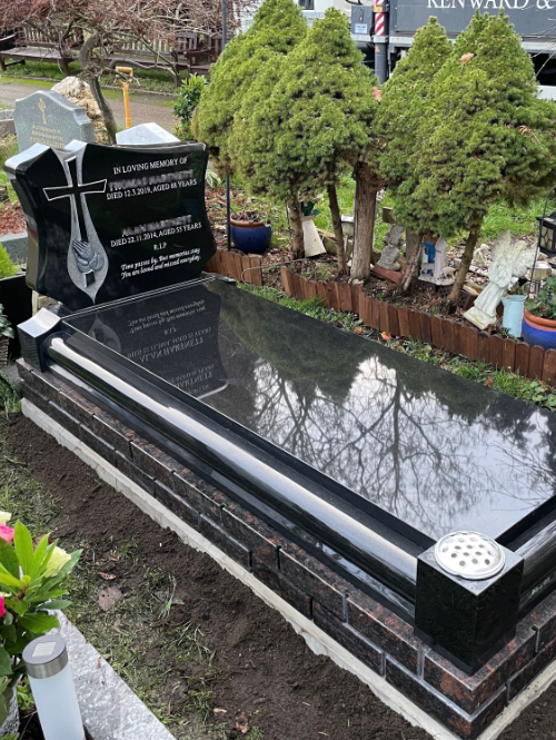Bespoke memorial in Black Granite with carved hands and cross, brick work effect in Cat Eye Brown Granite, cover slab.