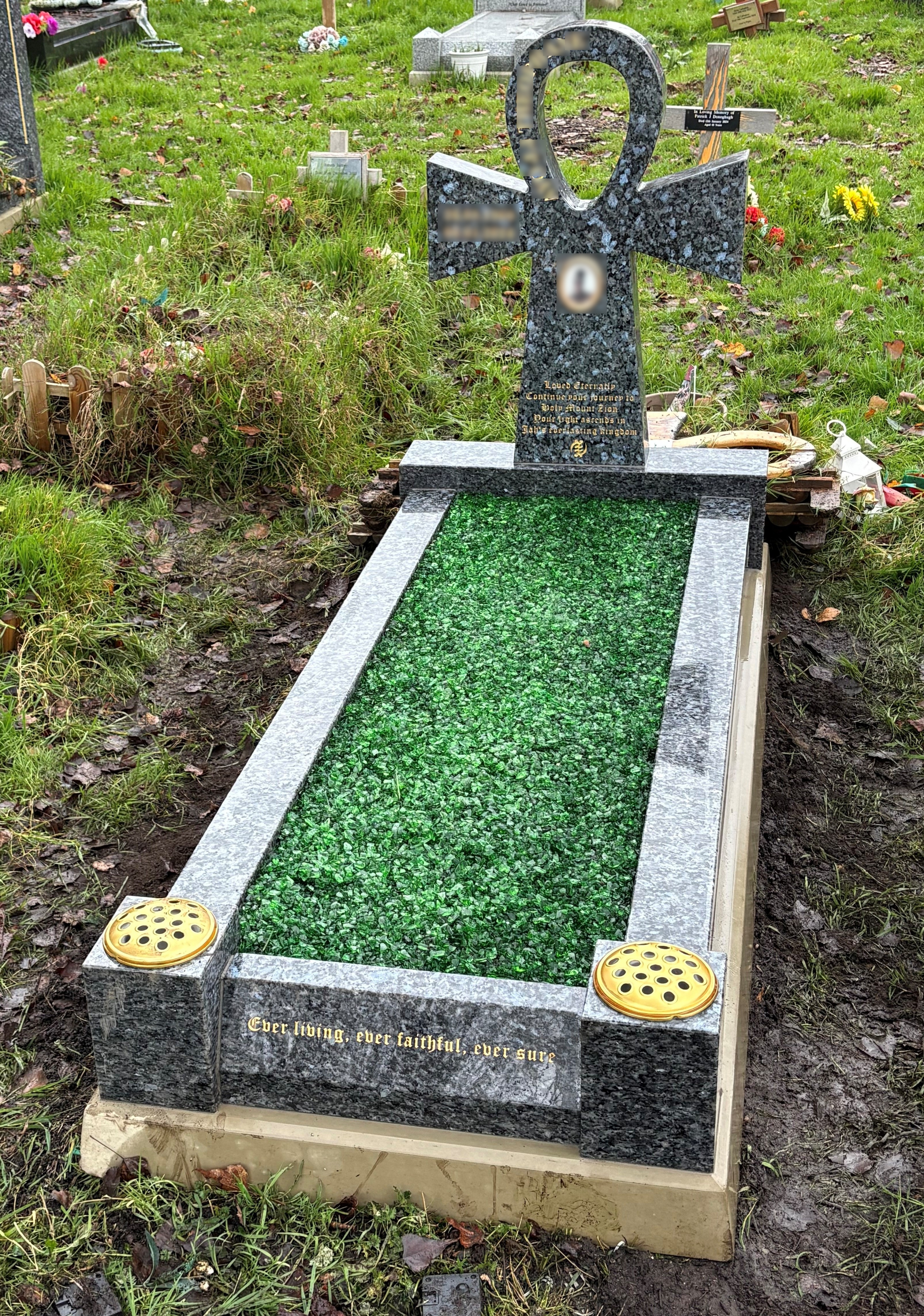 Blue Pearl granite Ankh cross full memorial with splayed foot kerb, shown with green chippings.