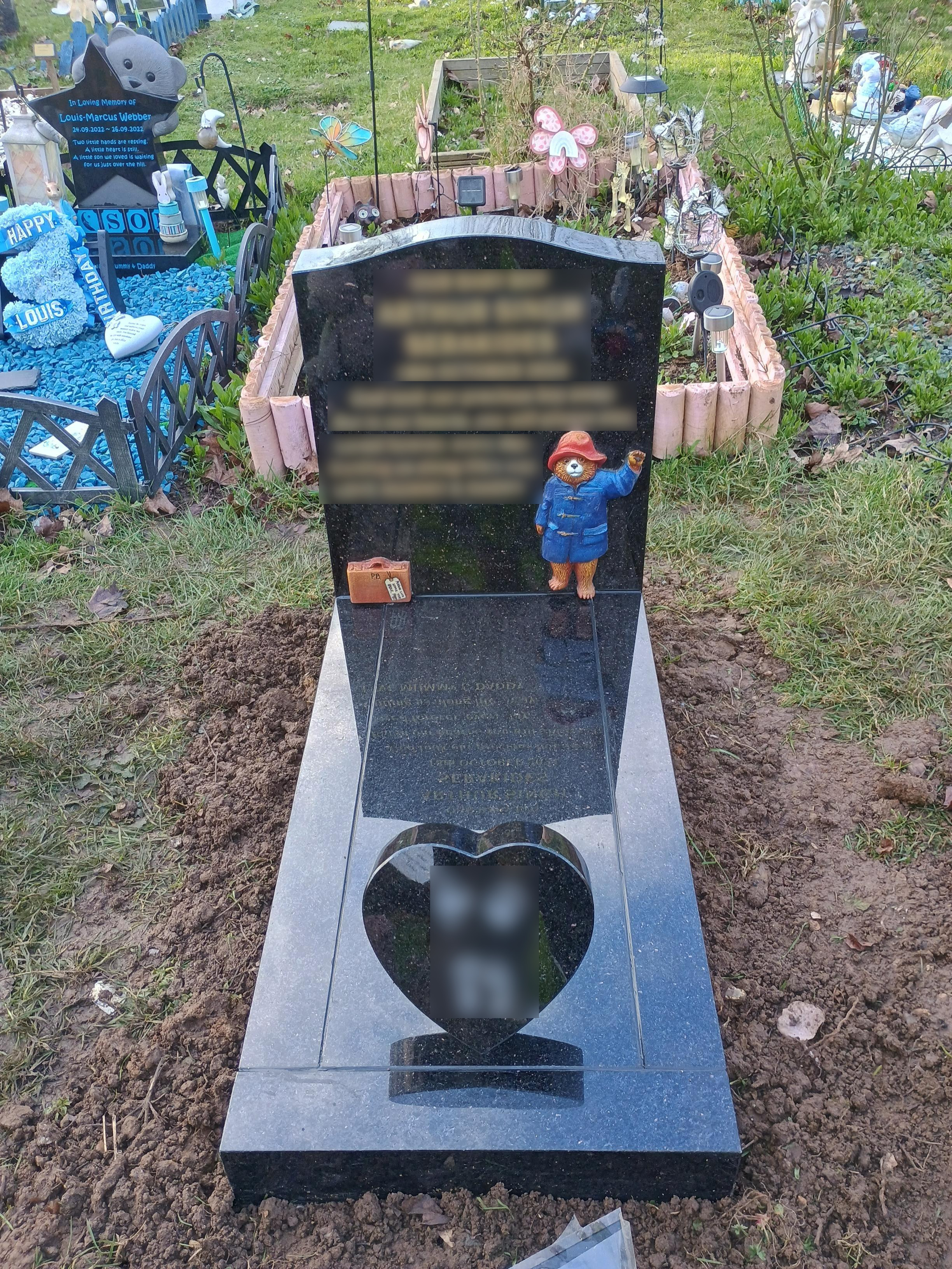 Star Galaxy granite ogee full  memorial with prominent hand carved and painted Paddington Bear upon return end kerb set  and cover slab, with small heart token on slab.