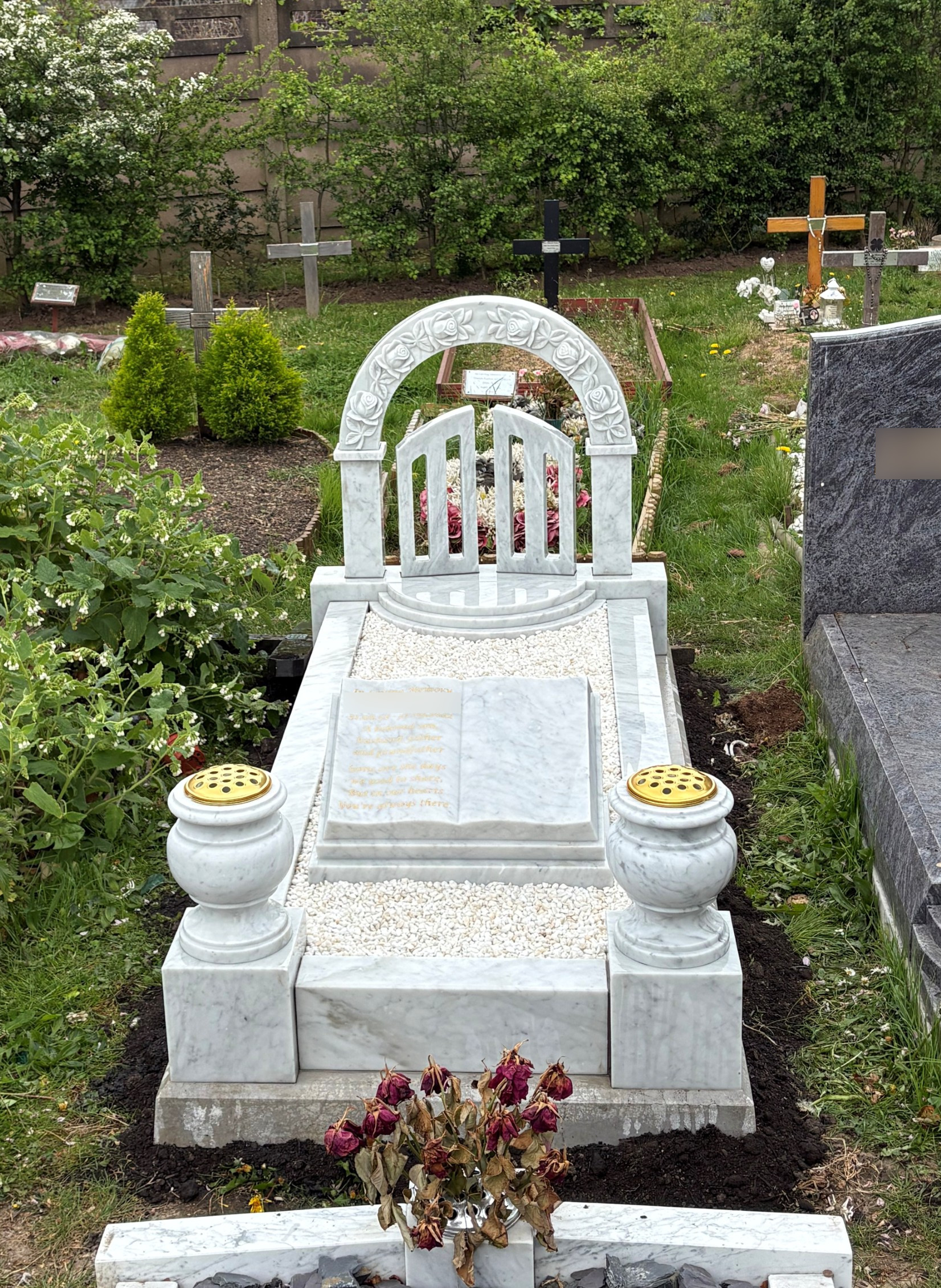 White Italian marble Gates of Heaven full memorial with delicately hand craved prominent rose design on arch, incorporating a book for wording and two turned vases.