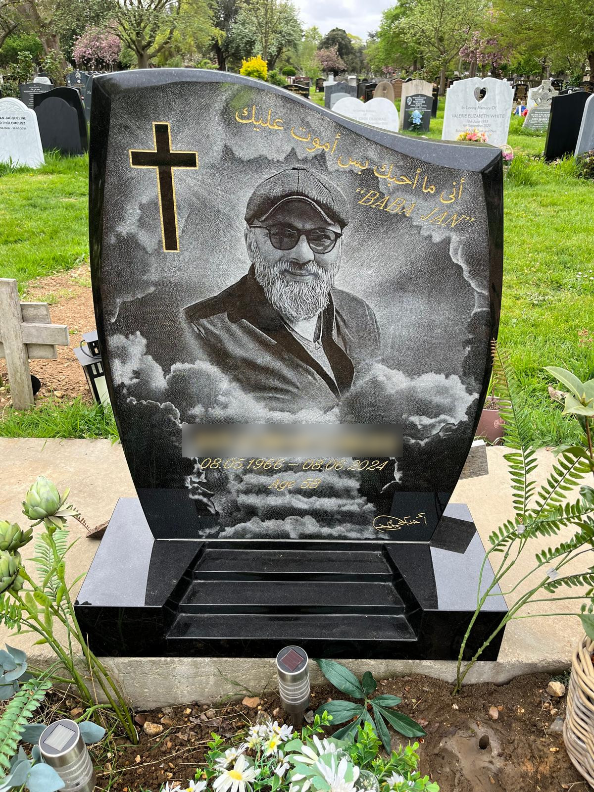 Black granite half ogee headstone with chamfered edge on a stepped base, with a hand etched photo covering the front of the headstone.